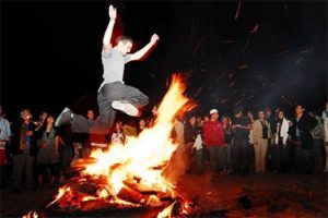 a boy is jumping over fire on International Day of Nowruz International Day of Nowruz Celebrations