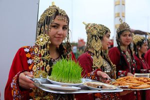 girls holding the dishes of nowruz day food International Day of Nowruz Celebrations